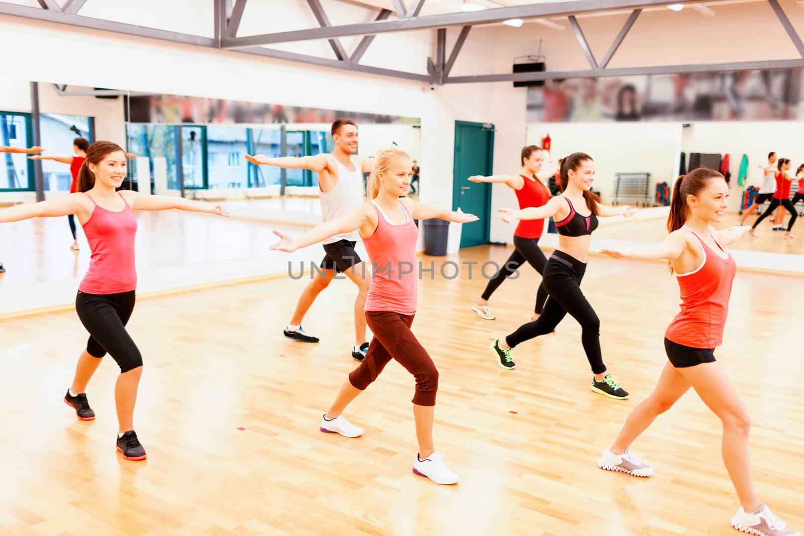 fitness, sport, training, gym and lifestyle concept - group of smiling people exercising in the gym