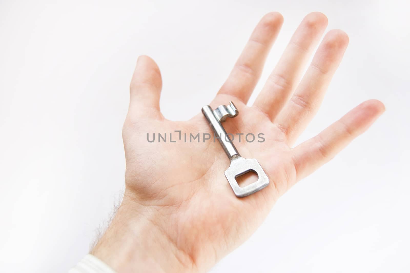 Key conceptual image. Man holds the key.