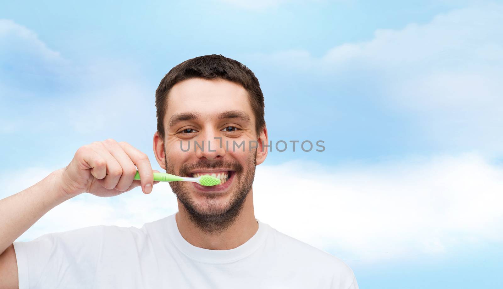 health and beauty concept - smiling young man with toothbrush