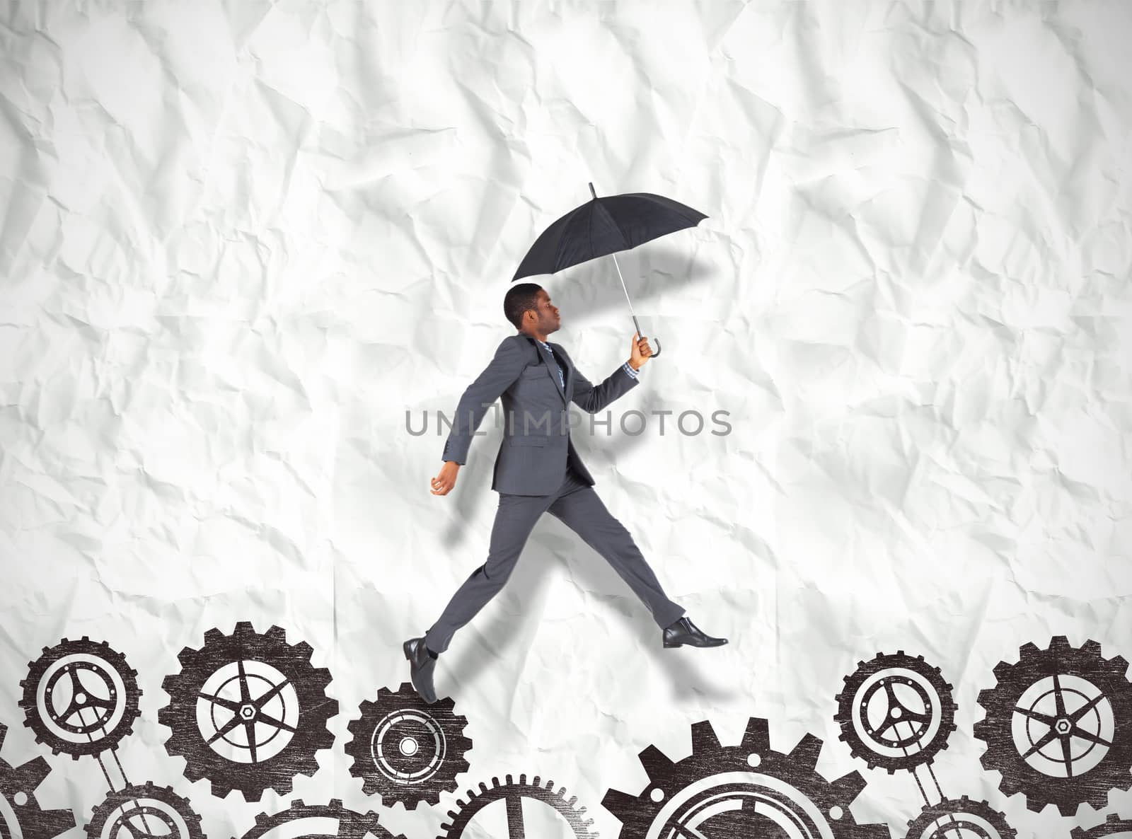 Composite image of businessman walking and holding umbrella by Wavebreakmedia