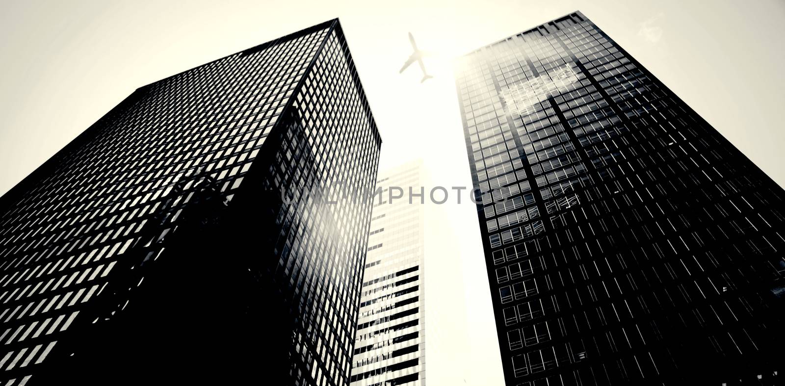 An airplane flying over buildings by Wavebreakmedia