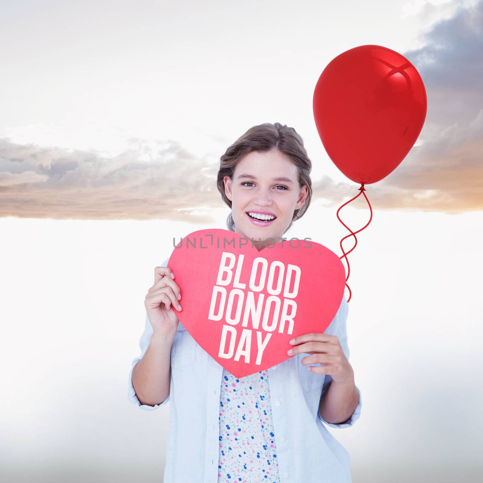 Composite image of woman holding heart card  by Wavebreakmedia