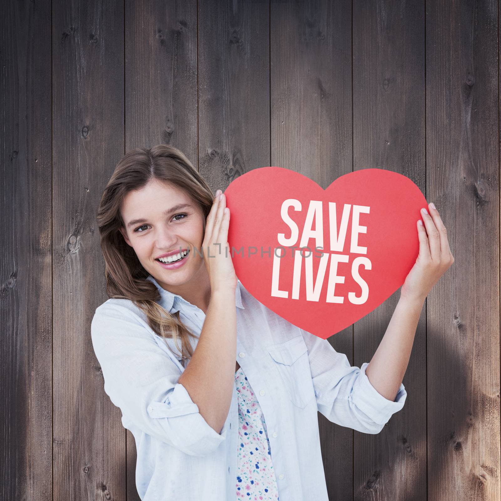 Woman holding heart card  against wooden planks