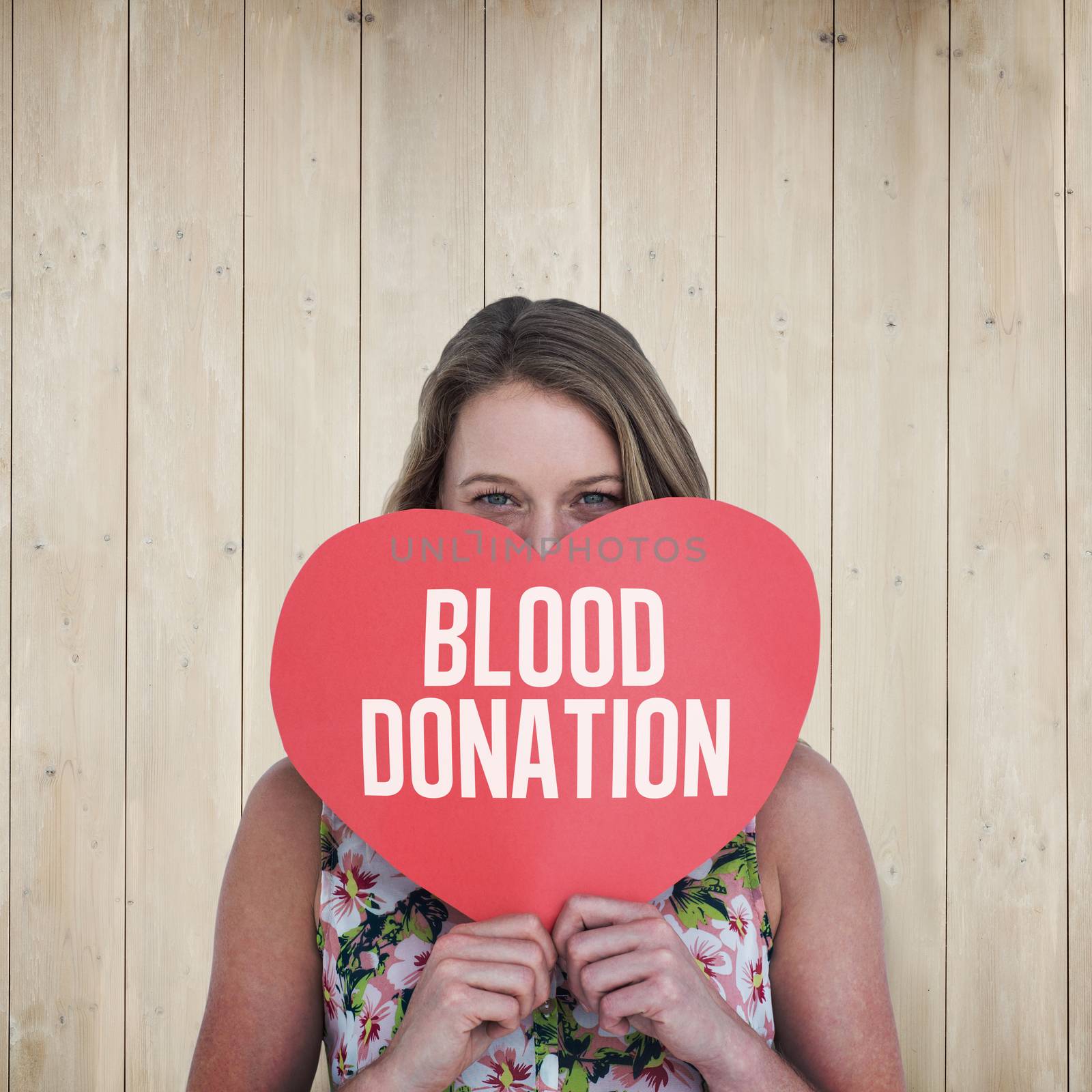 Woman holding heart card  against wooden planks