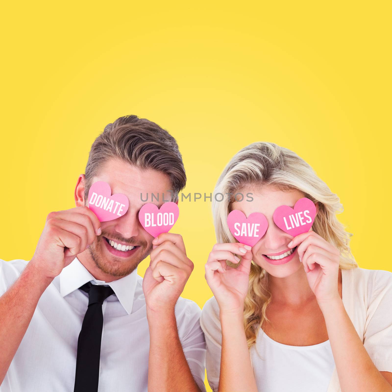 Attractive young couple holding pink hearts over eyes against yellow vignette