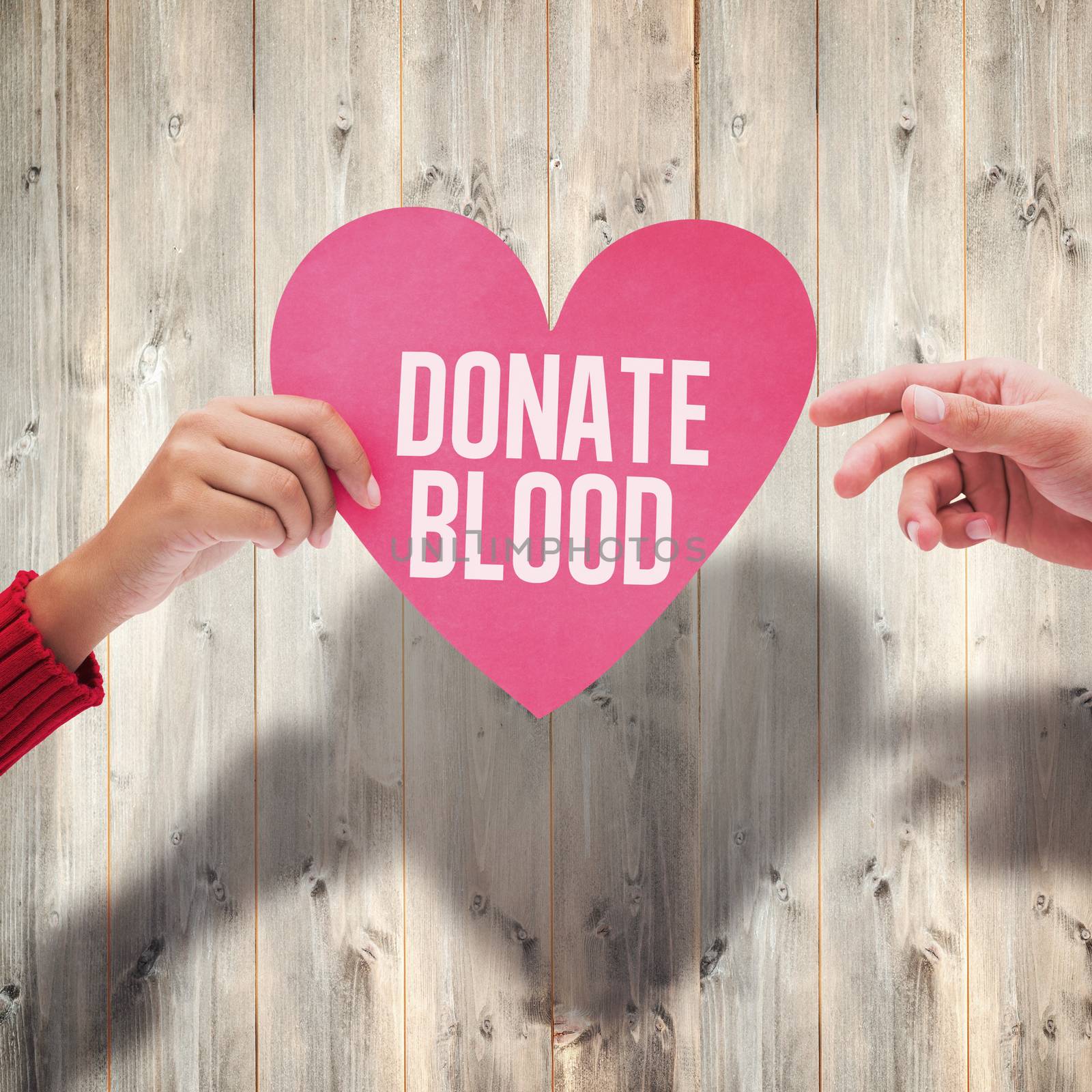 Couple holding a heart against pale wooden planks