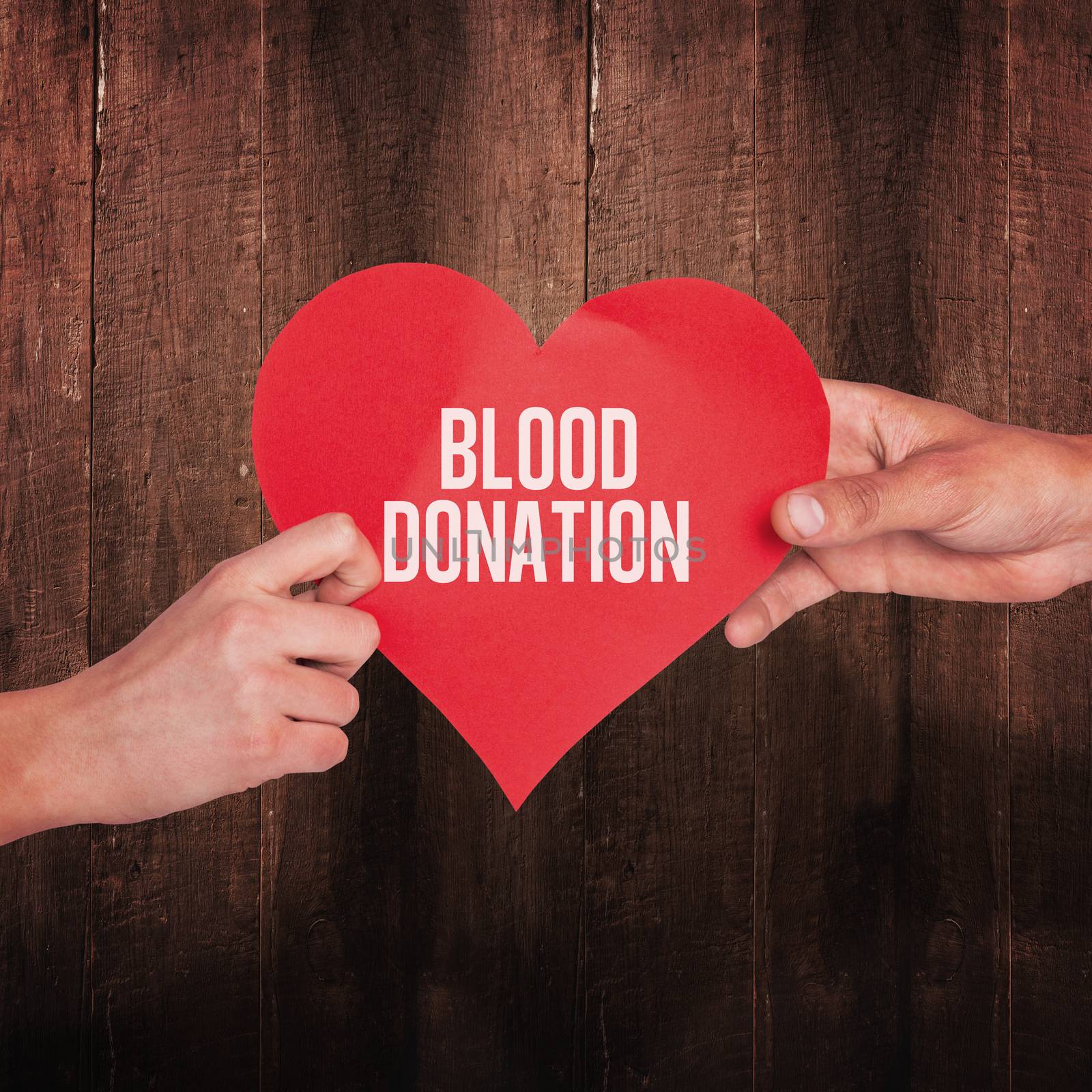 Hands holding red heart against weathered oak floor boards background