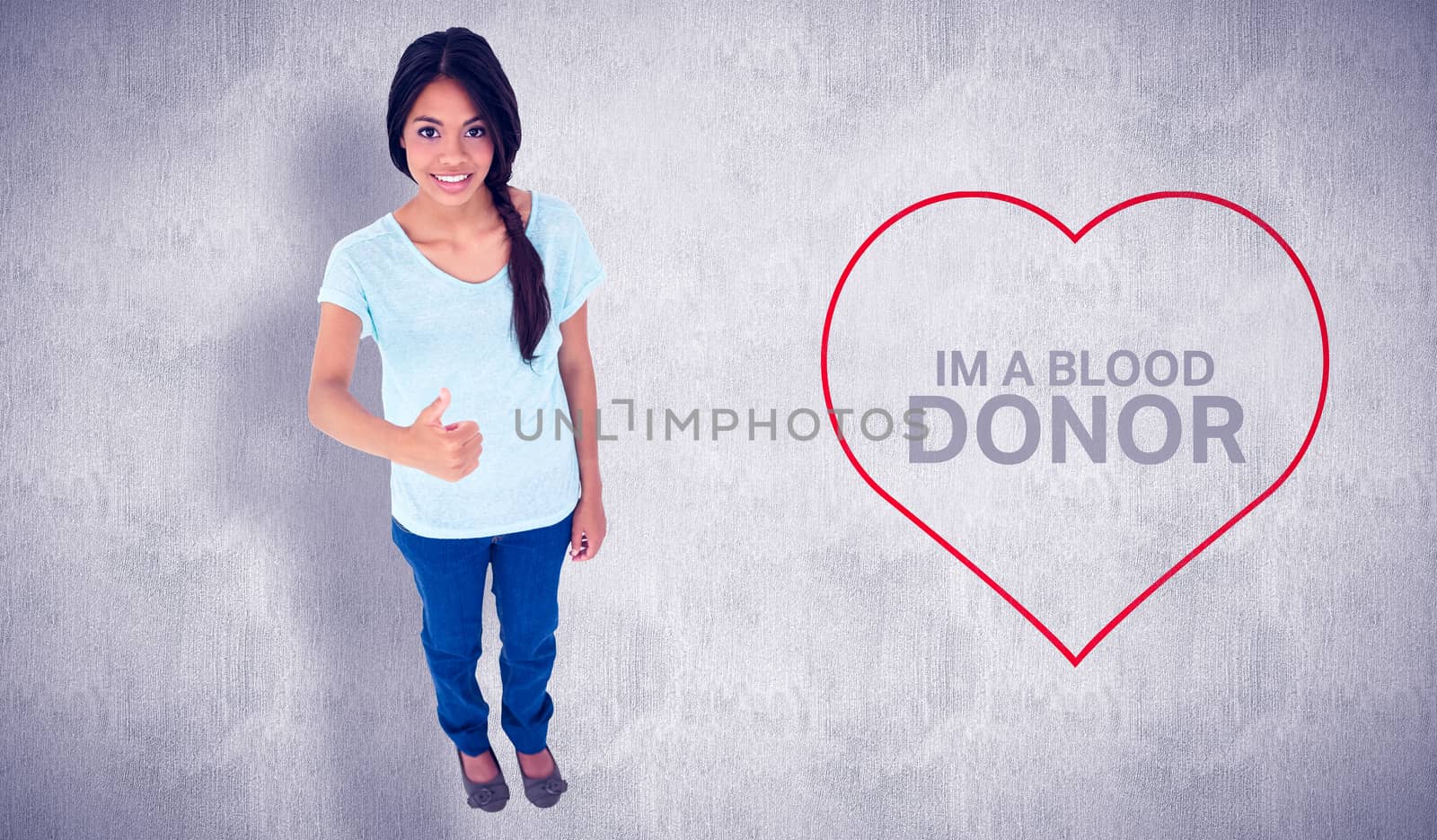 Happy brunette giving thumbs up against white and grey background