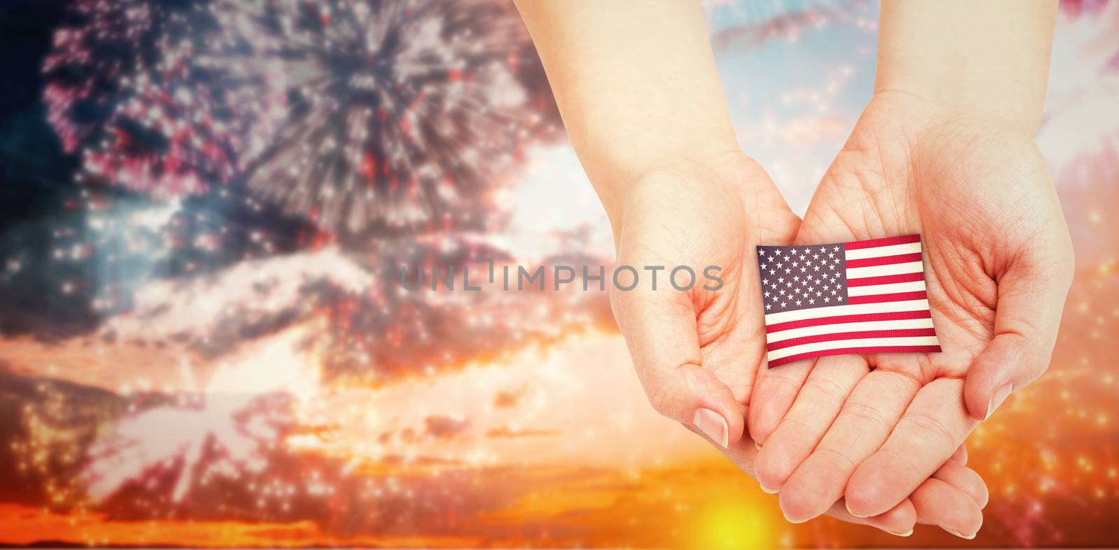 Hands presenting against colourful fireworks exploding on black background