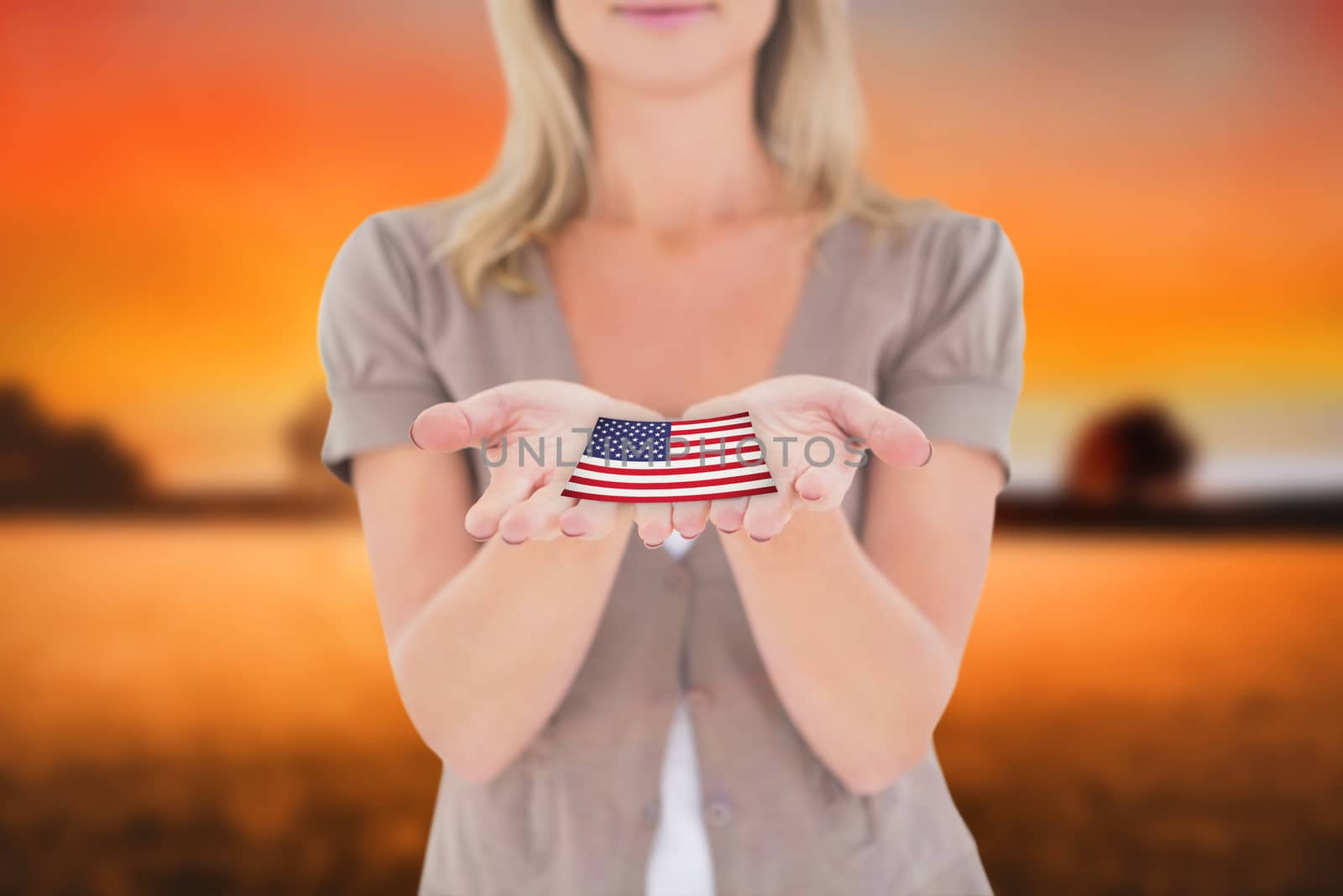 Happy blonde holding our her hands against countryside scene