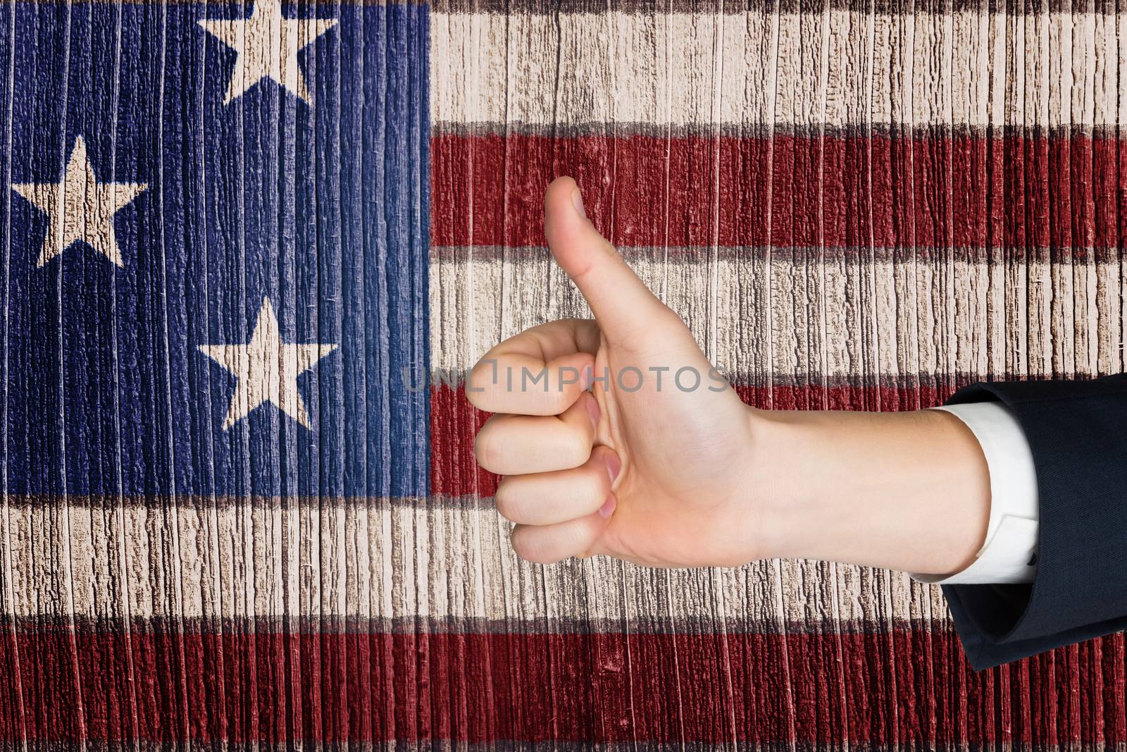 Hand showing thumbs up against digitally generated grey wooden planks
