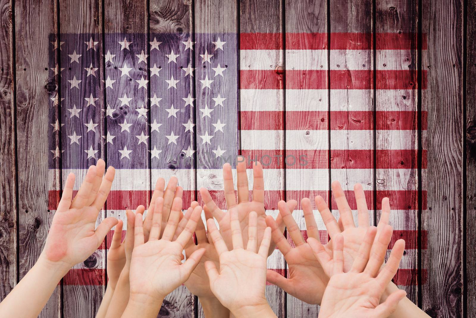 People raising hands in the air against digitally generated grey wooden planks