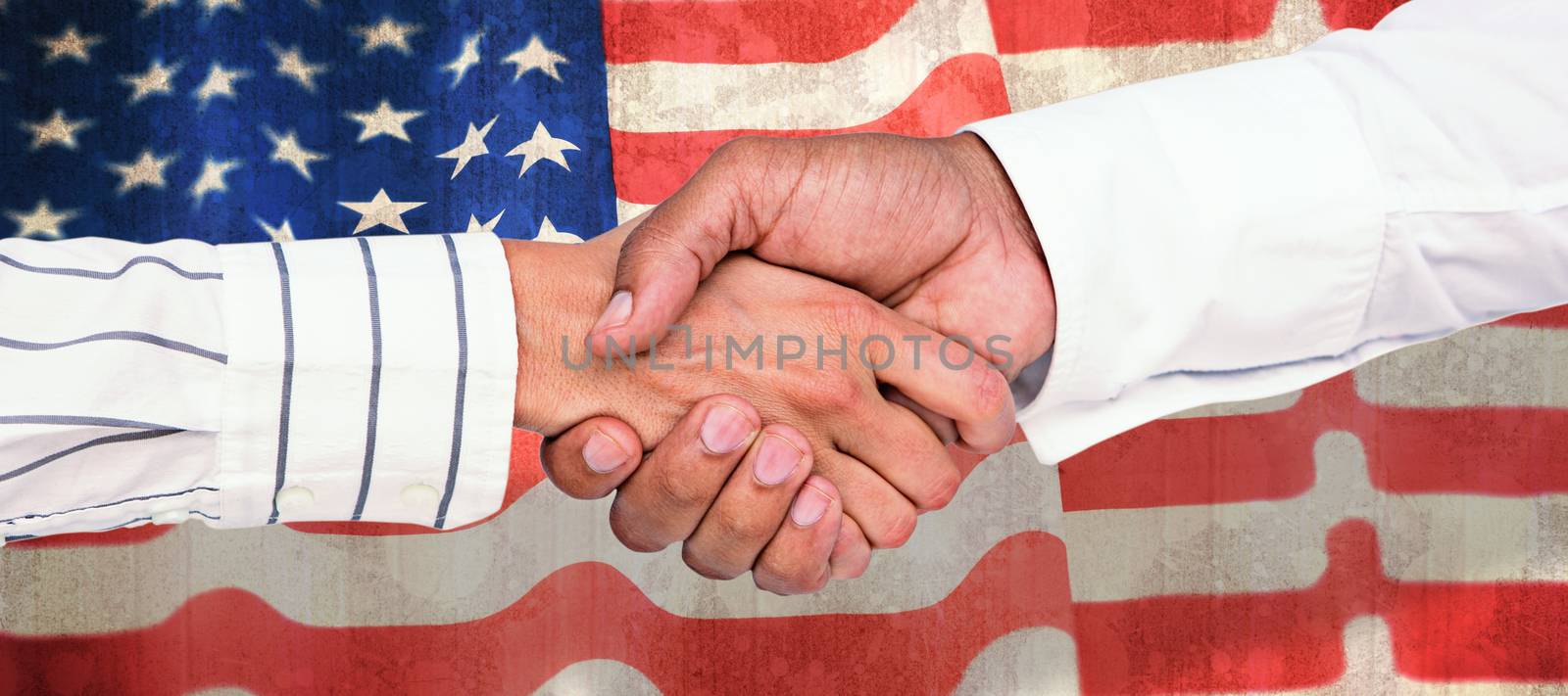 Business people shaking hands against paint splattered paper