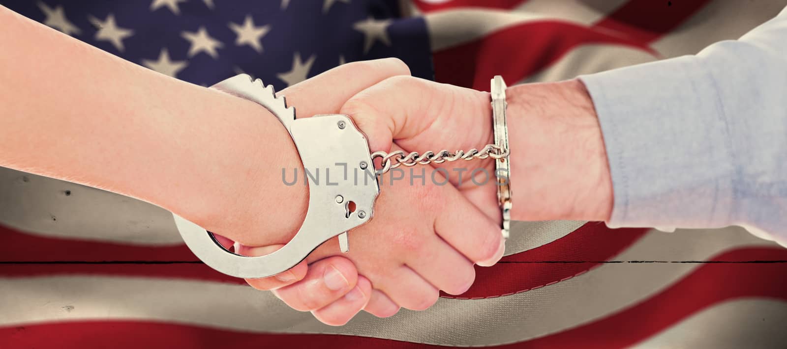 Composite image of handcuffed business people shaking hands by Wavebreakmedia