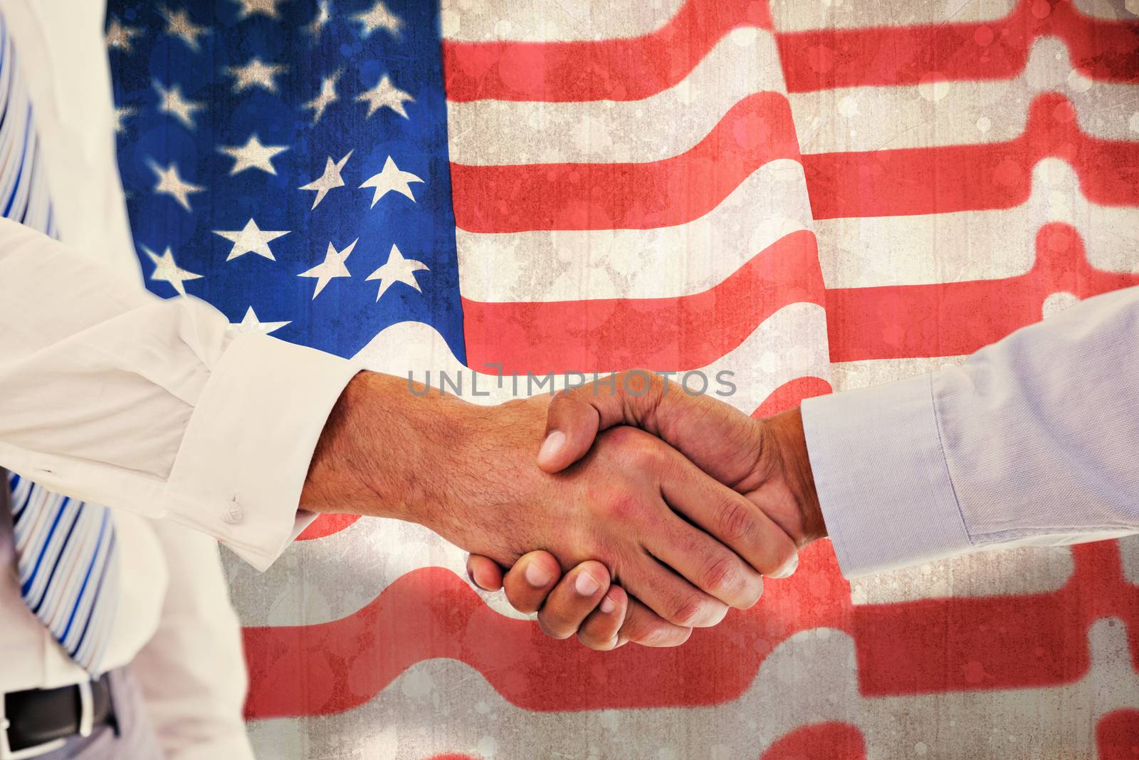 Close-up shot of a handshake in office against paint splattered paper