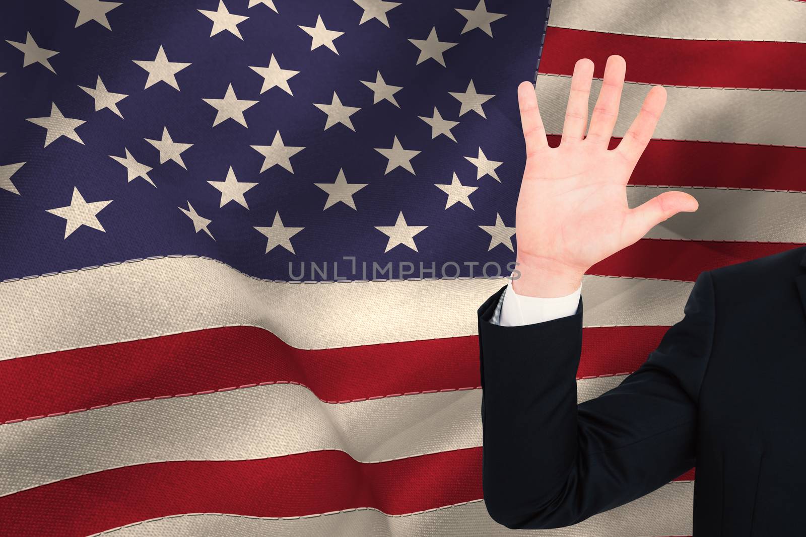 Businessman in suit with hand raised against united states of america flag