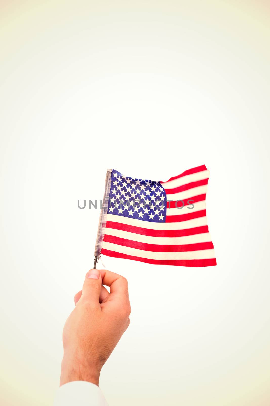 Hand waving american flag against white background with vignette