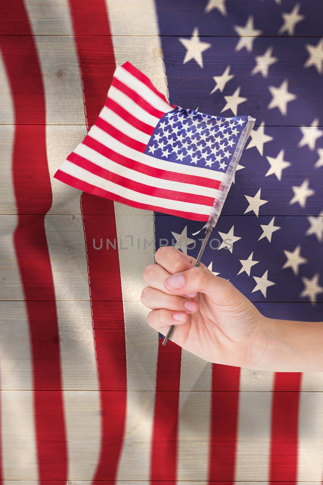 Composite image of hand waving american flag by Wavebreakmedia