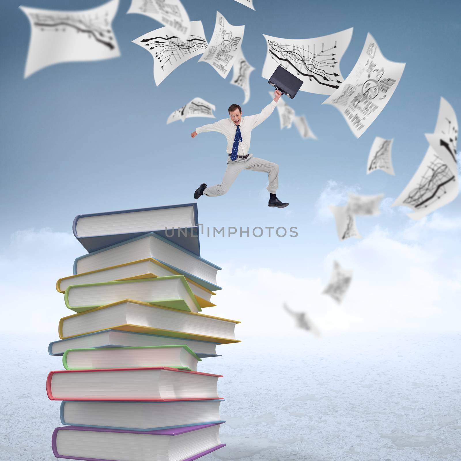 Cheerful jumping businessman with his suitcase against stack of books