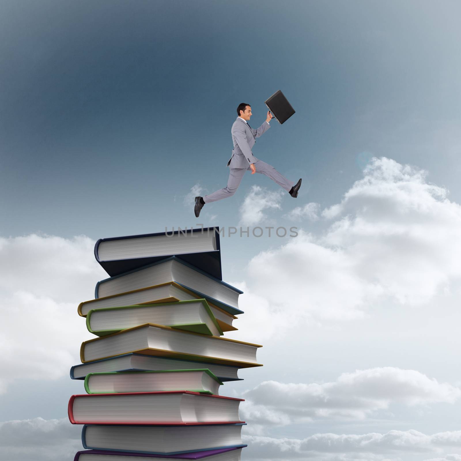 Businessman running with a suitcase against stack of books