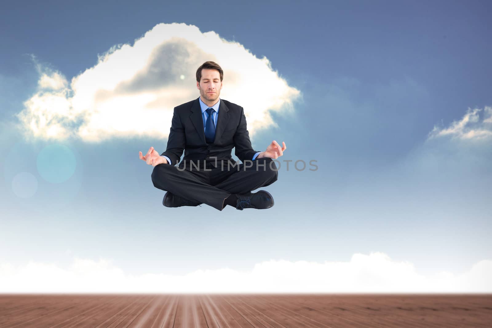 Calm businessman sitting in lotus pose against cloudy sky background