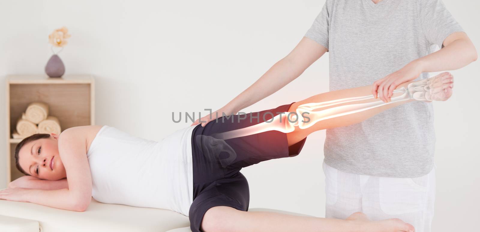 Digital composite of Highlighted bones of woman at physiotherapist 