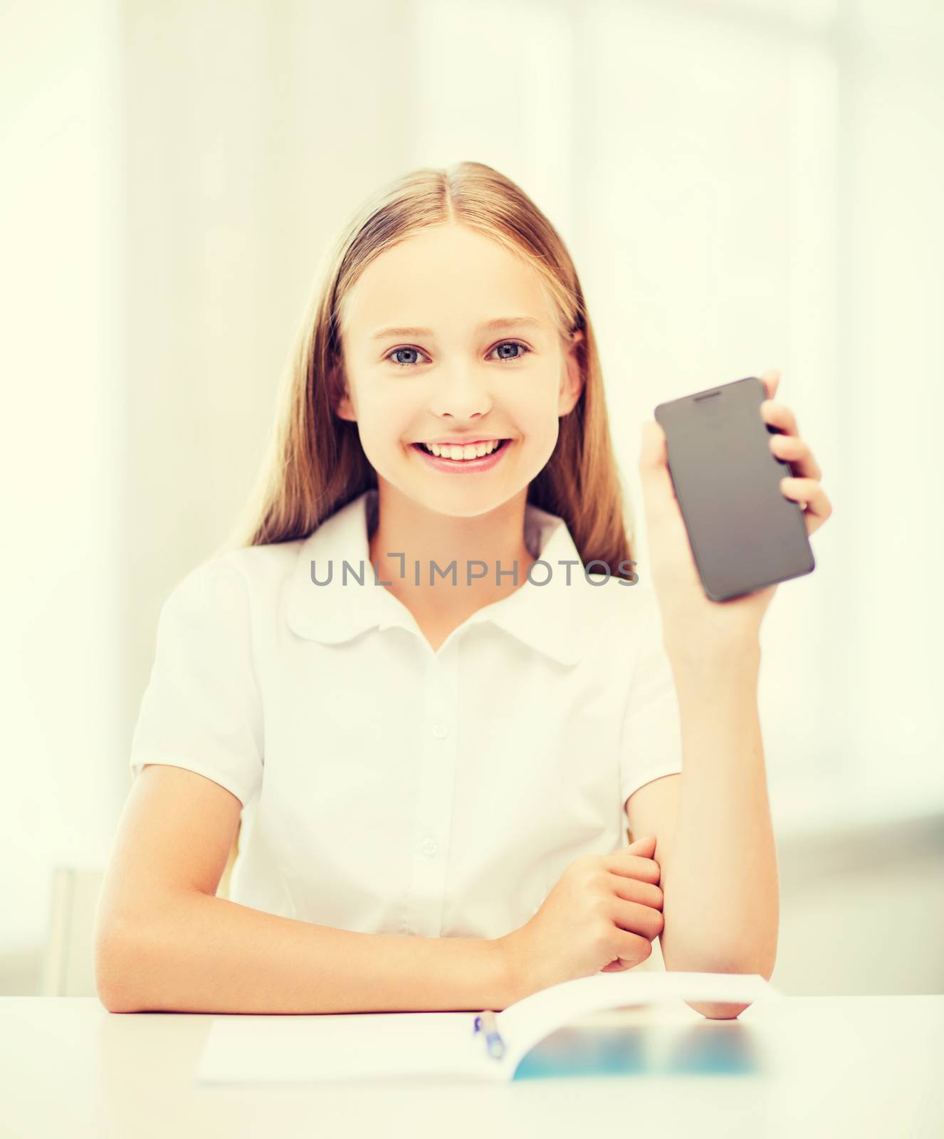 education, school, technology and internet concept - little student girl with smartphone at school