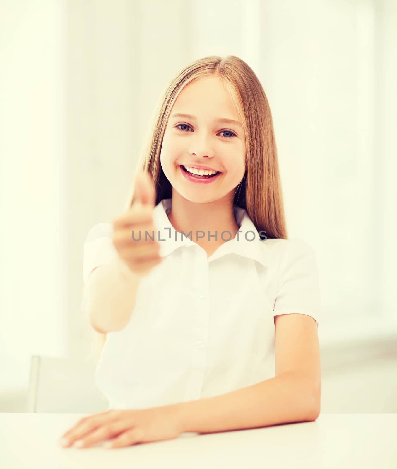 education and school concept - little student girl showing thumbs up at school