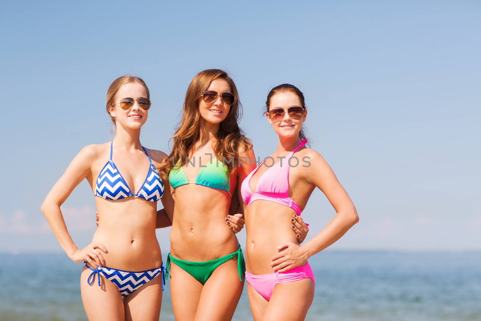 group of smiling young women on beach by dolgachov