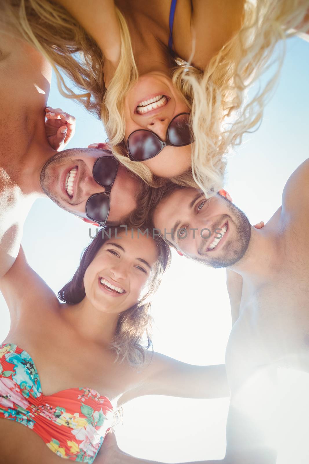 group of friends in swimsuits taking a selfie at the beach