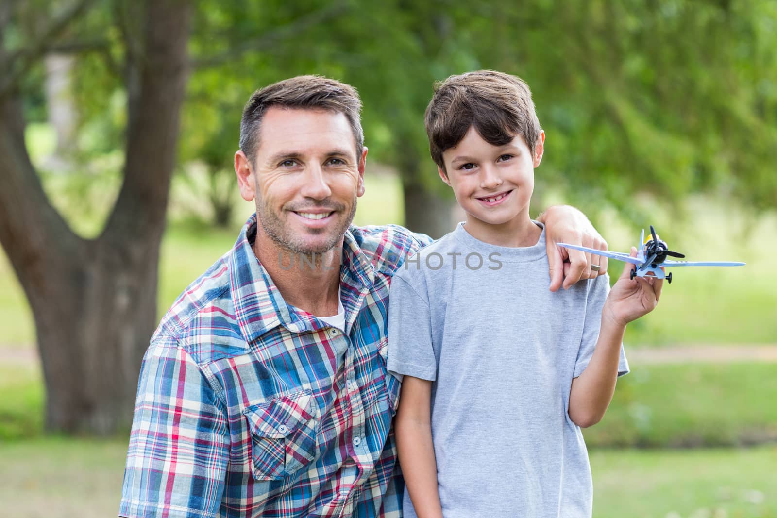 Father and son having fun in the park on a sunny day