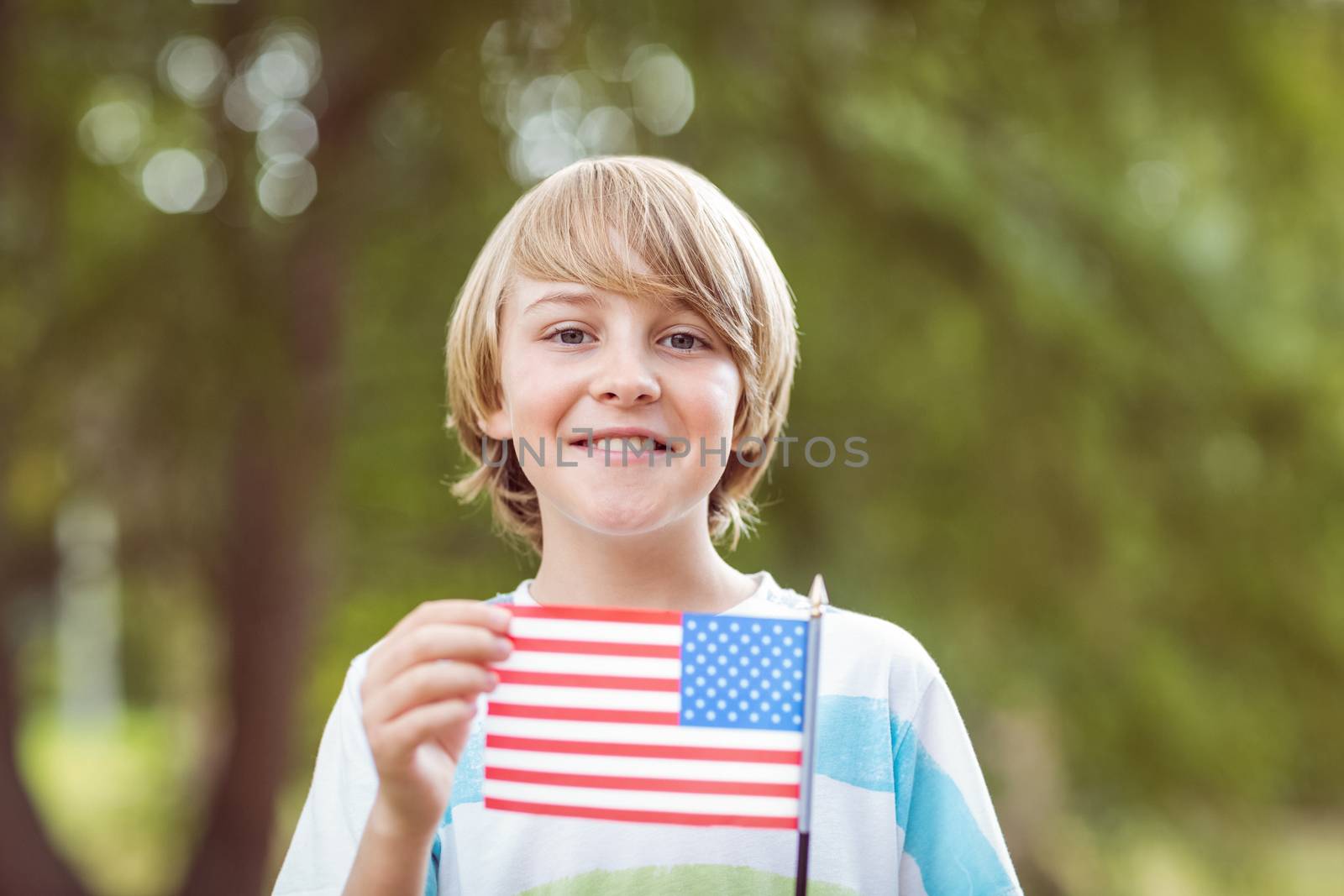 Young boy holding an american flag  by Wavebreakmedia