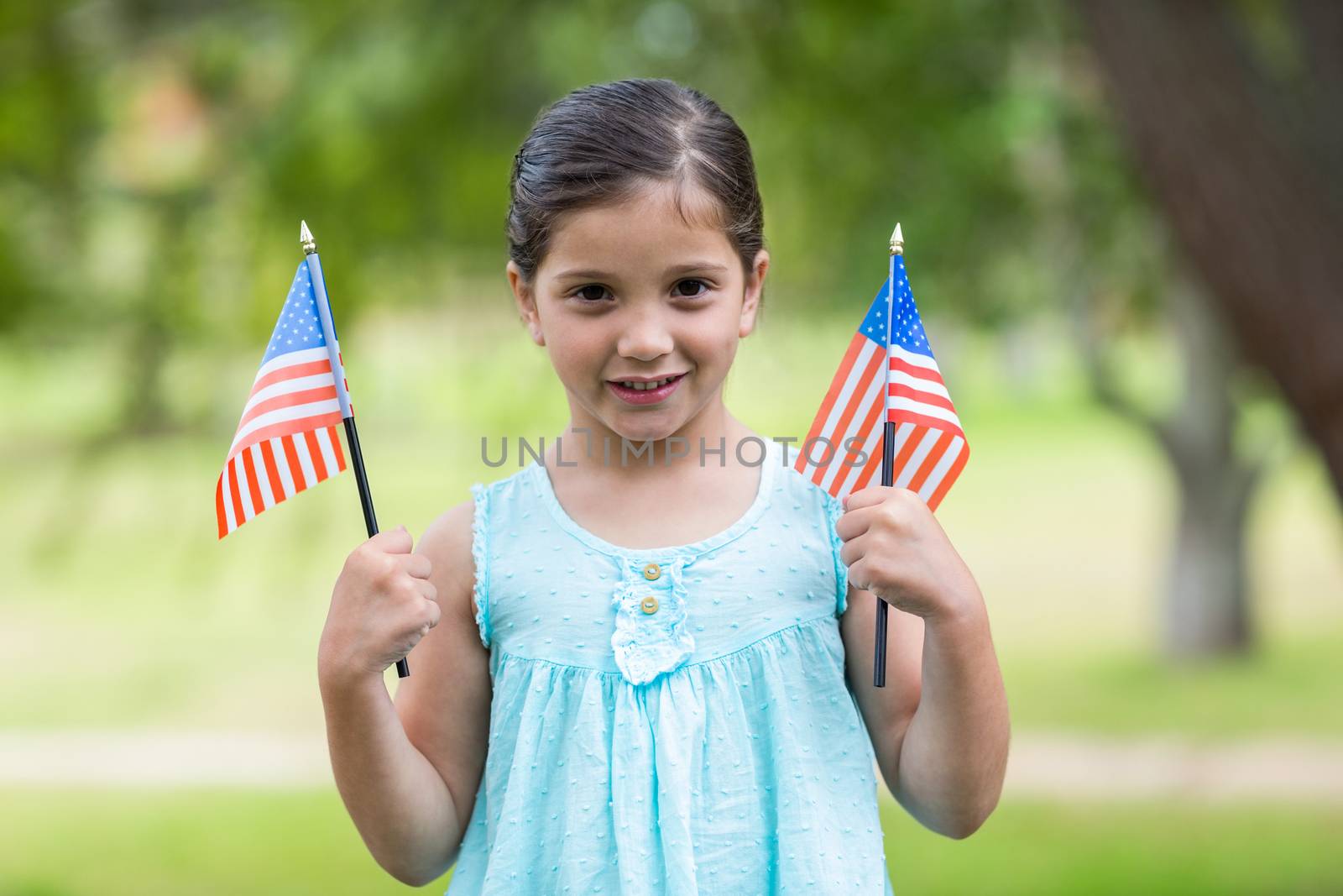 Little girl waving american flag by Wavebreakmedia