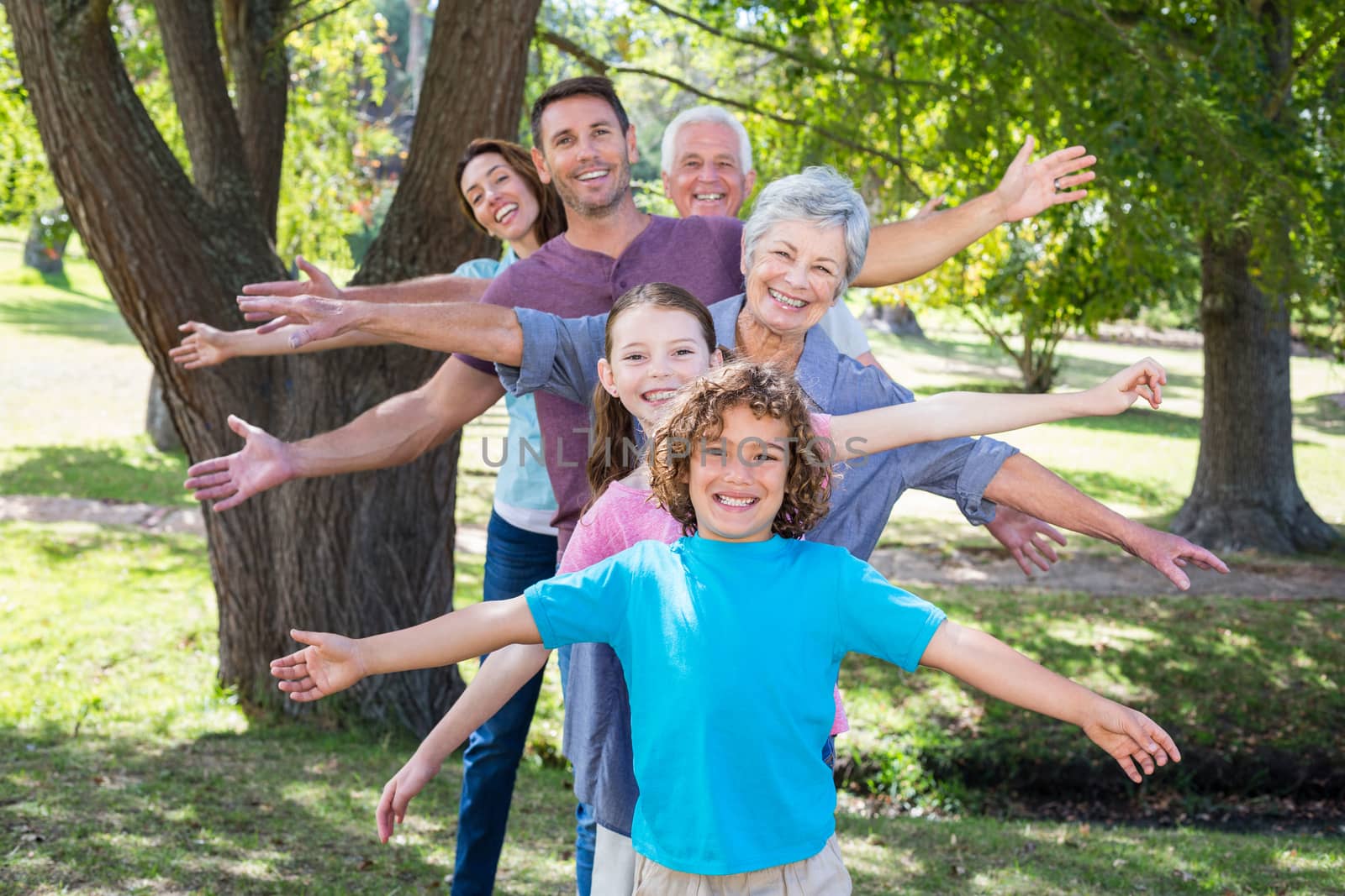 Extended family smiling in the park by Wavebreakmedia