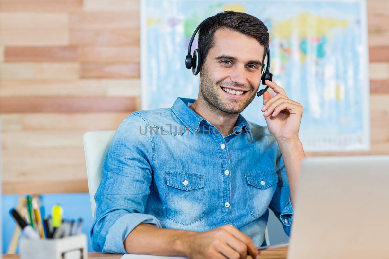 Handsome travel agent smiling at camera by Wavebreakmedia