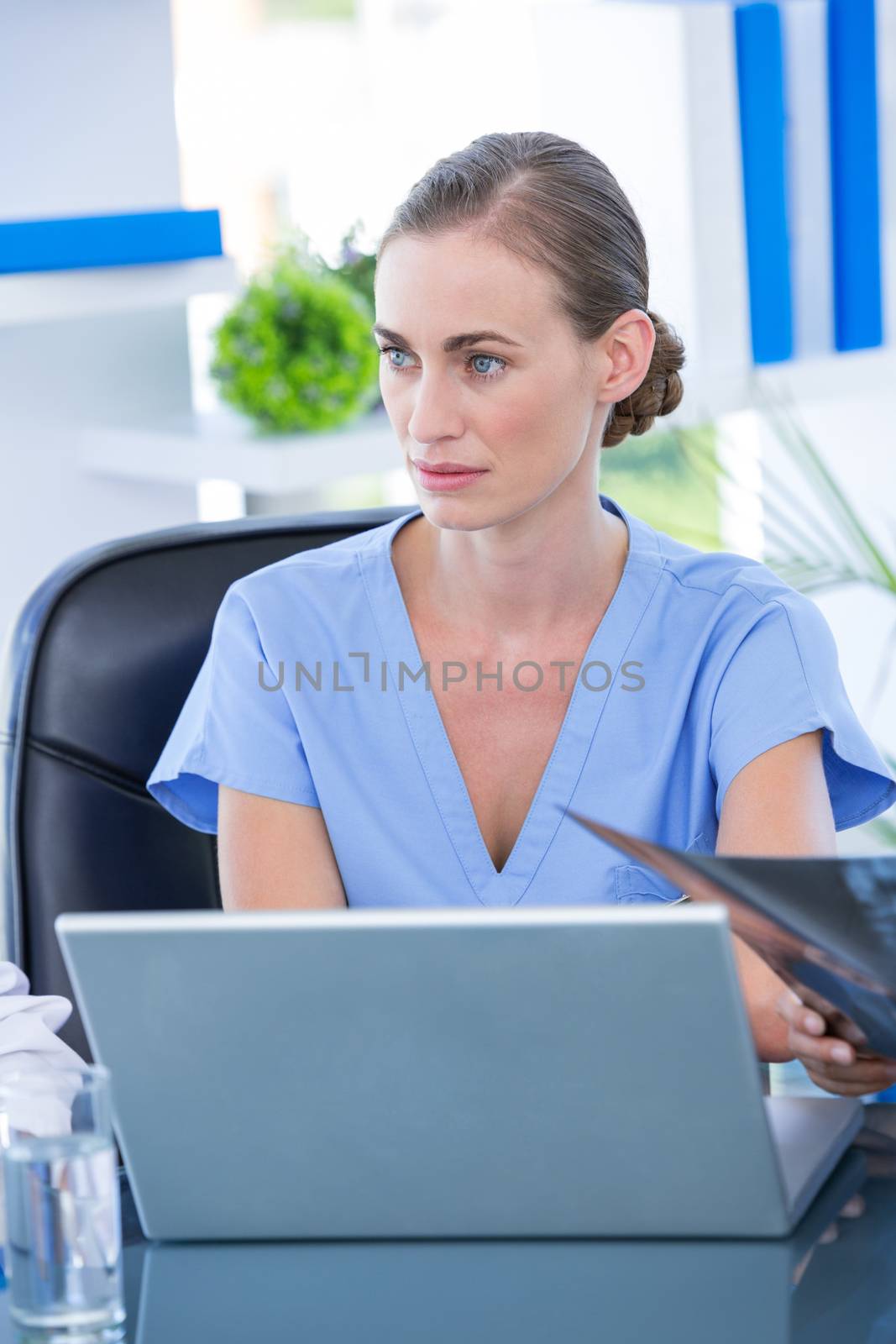 Doctor working on her laptop and calling on a white screen