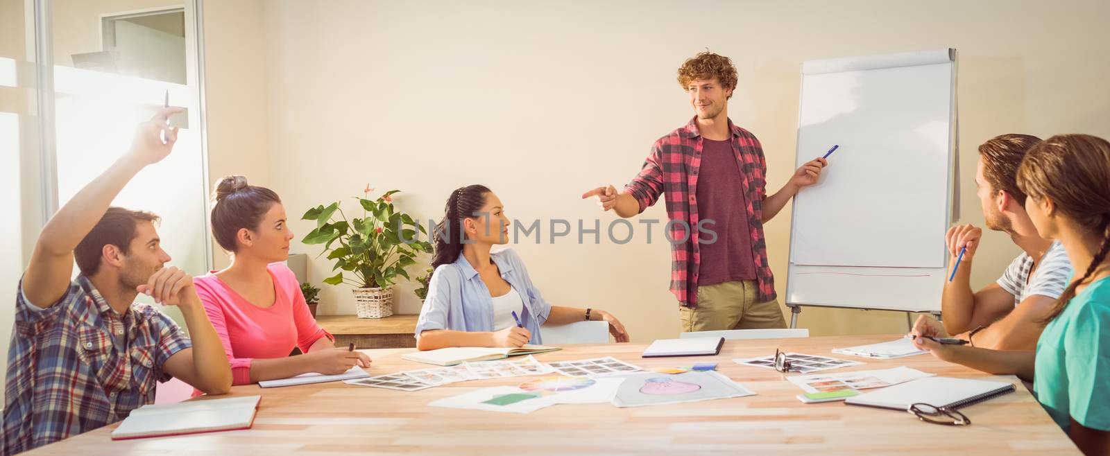 Casual young businessman giving a presentation to his colleagues