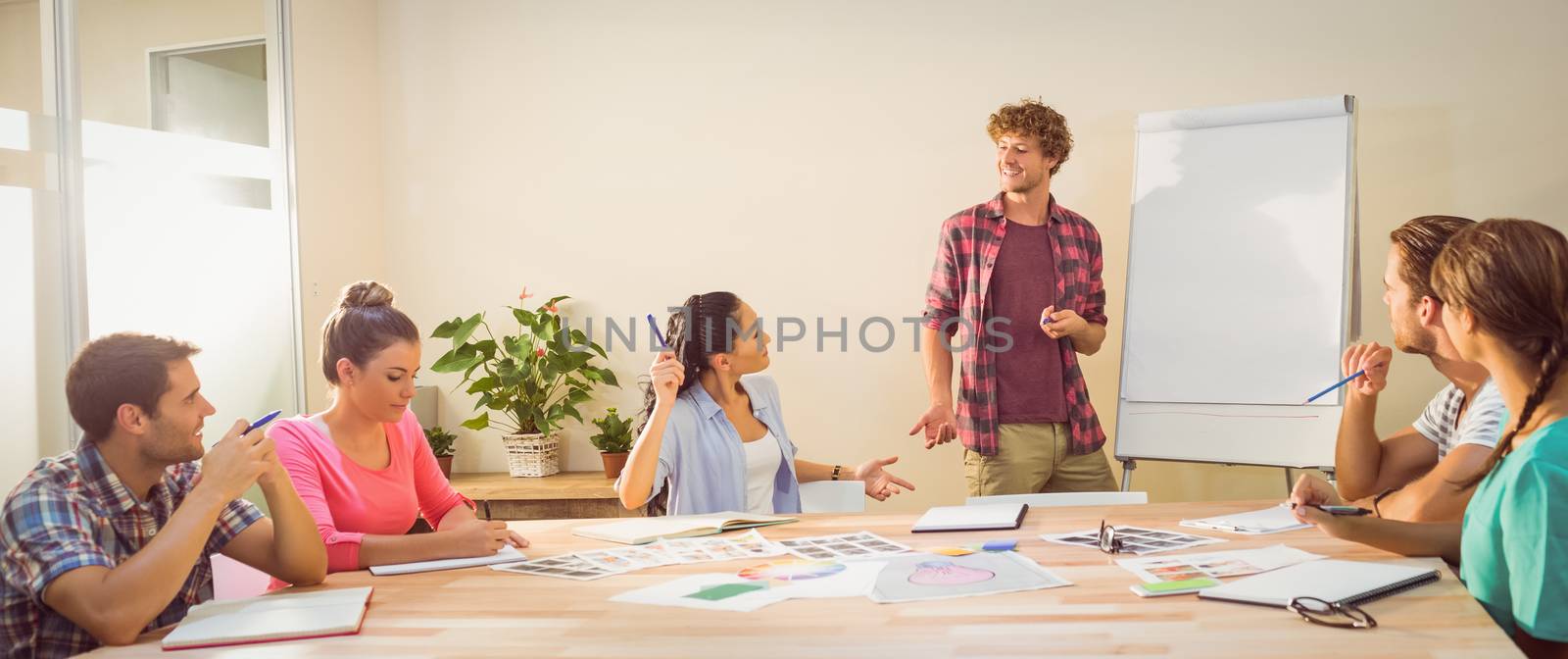 Casual young businessman giving a presentation to his colleagues