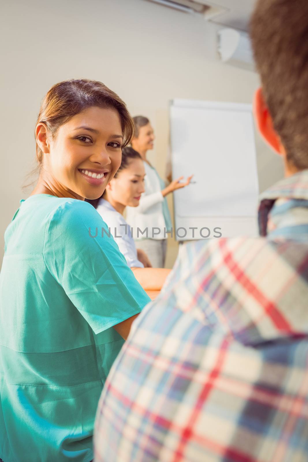 A young female designer listening to a conference in the office