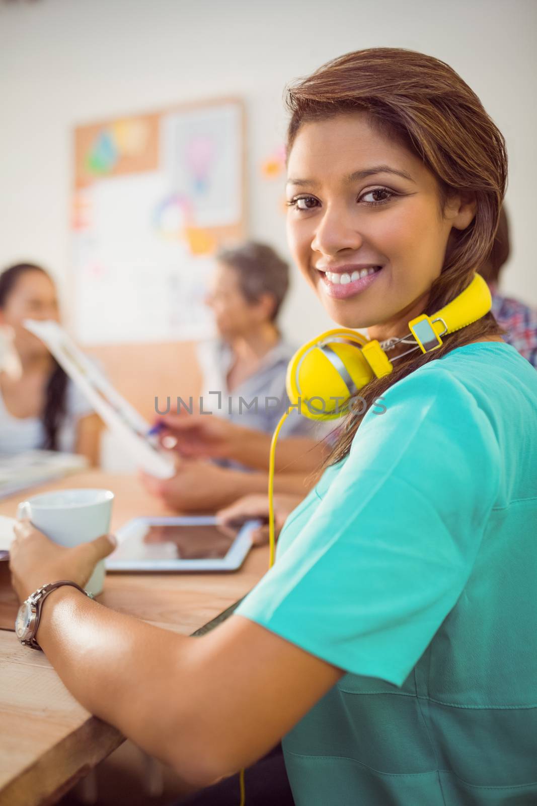 Smiling businesswoman with headphones in a meeting by Wavebreakmedia