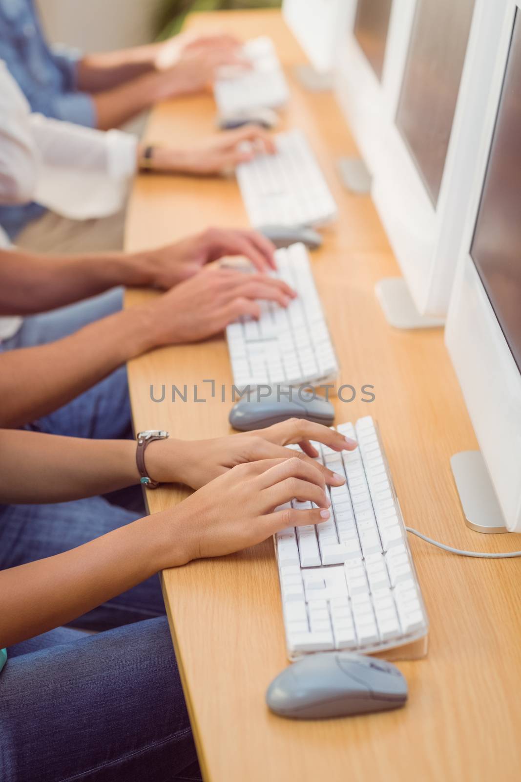 Business people typing on a keyboard in a row