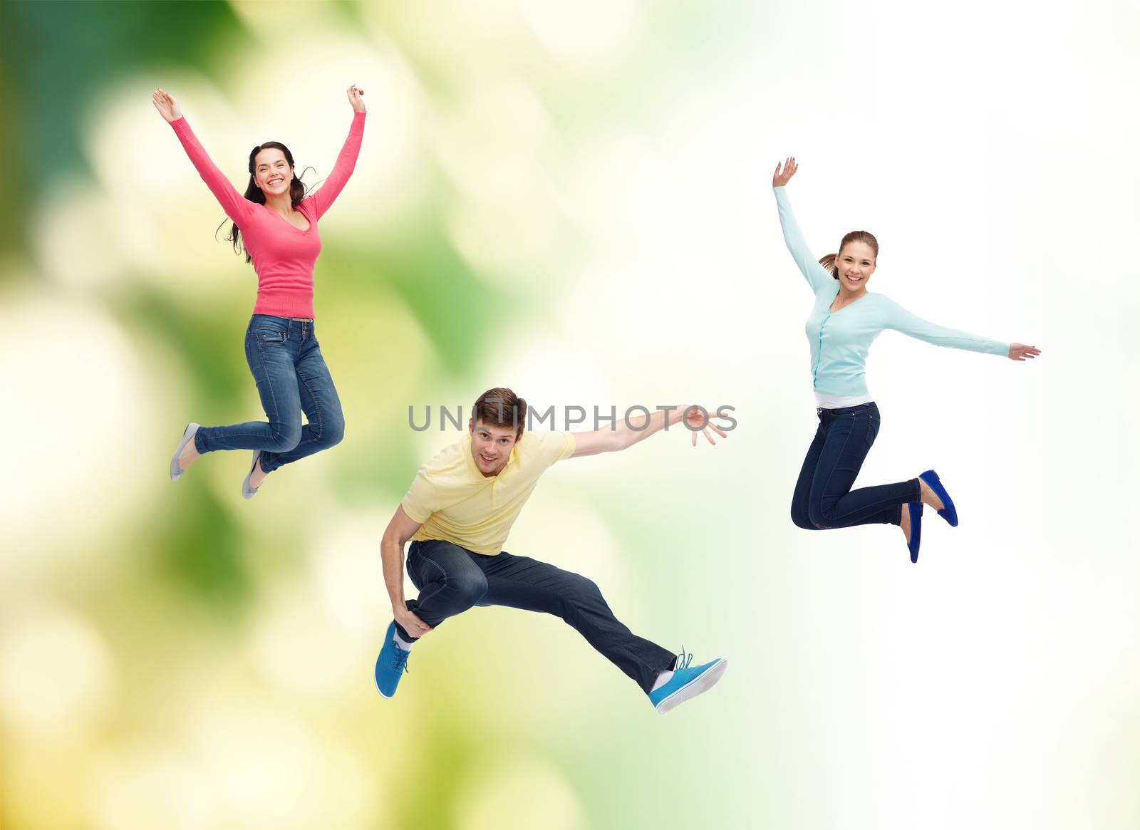 group of smiling teenagers jumping in air by dolgachov