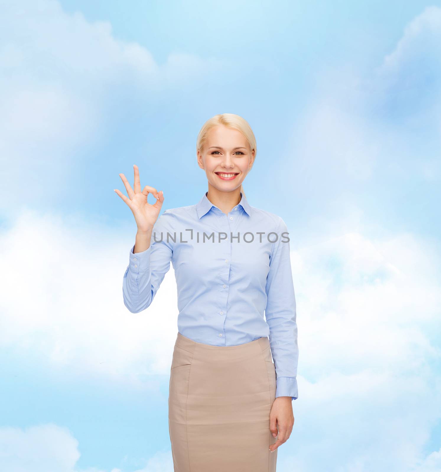 smiling businesswoman showing ok-sign with hand by dolgachov