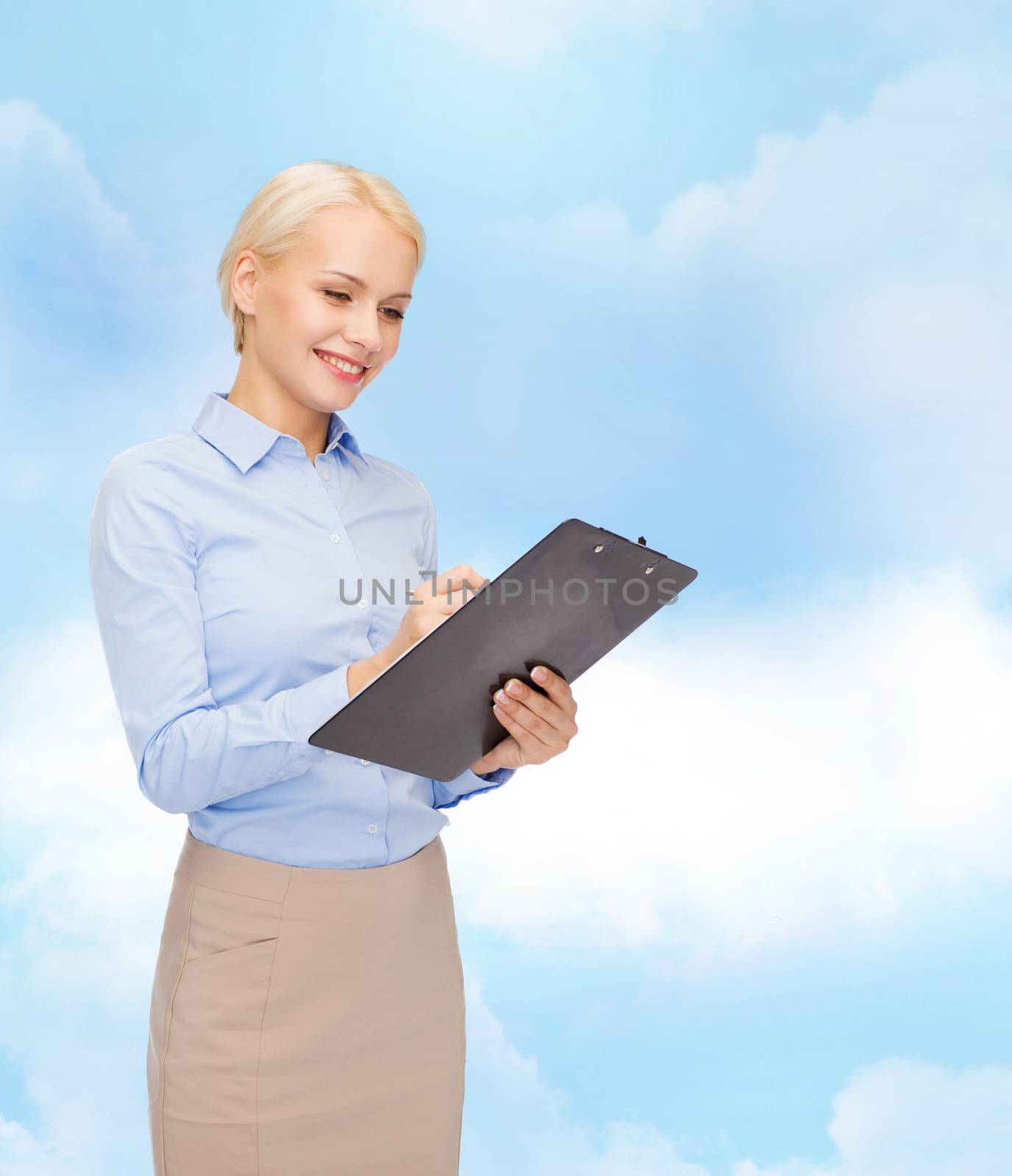 business and education concept - friendly young smiling businesswoman with clipboard and pen