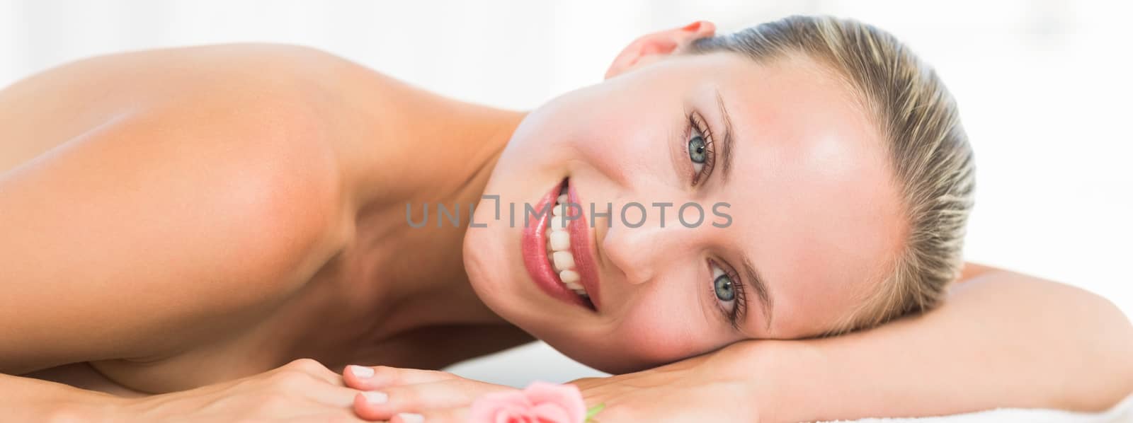 Peaceful blonde lying on towel smiling at camera by Wavebreakmedia