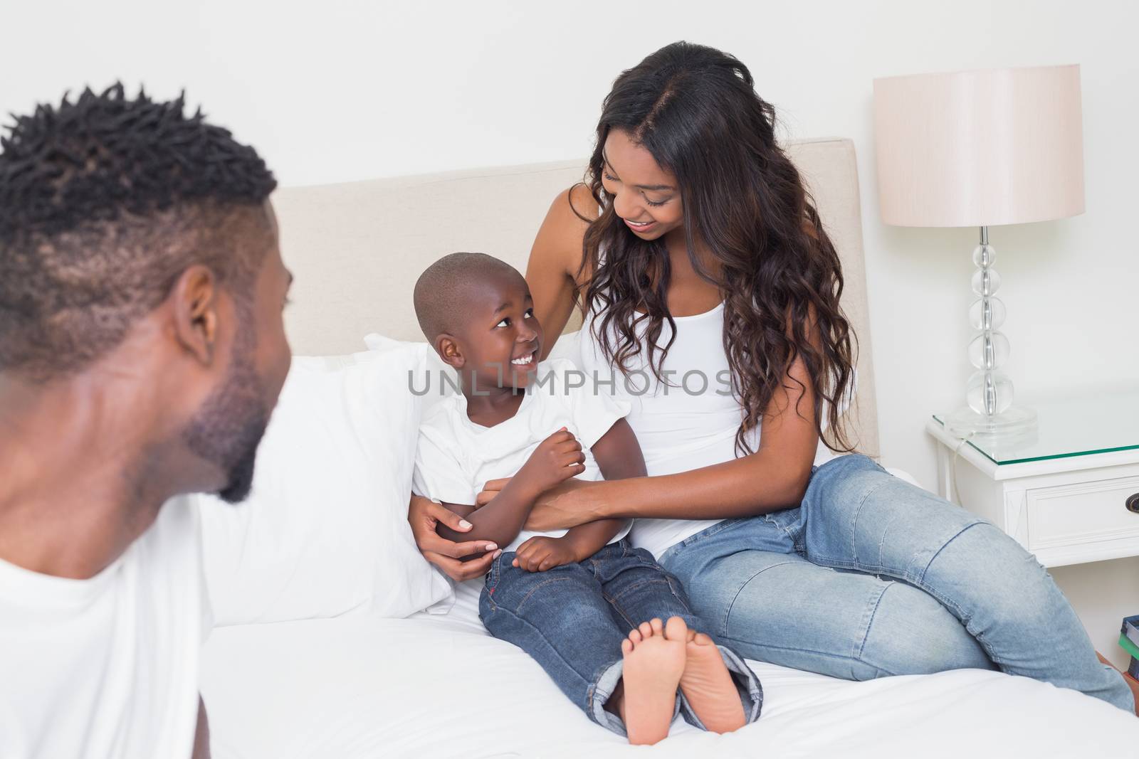 Happy family on the bed at home in bedroom