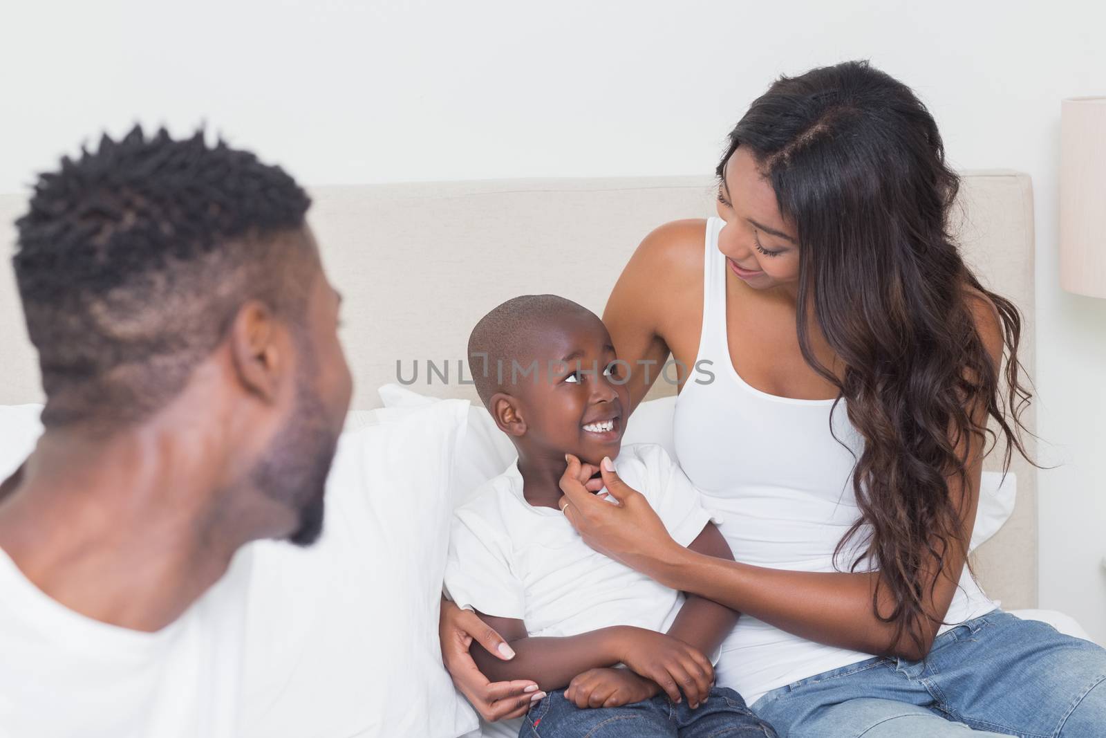 Happy family on the bed at home in bedroom