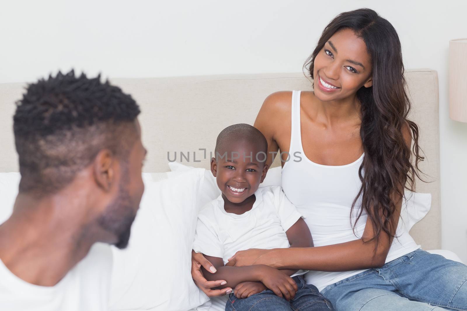 Happy family on the bed at home in bedroom