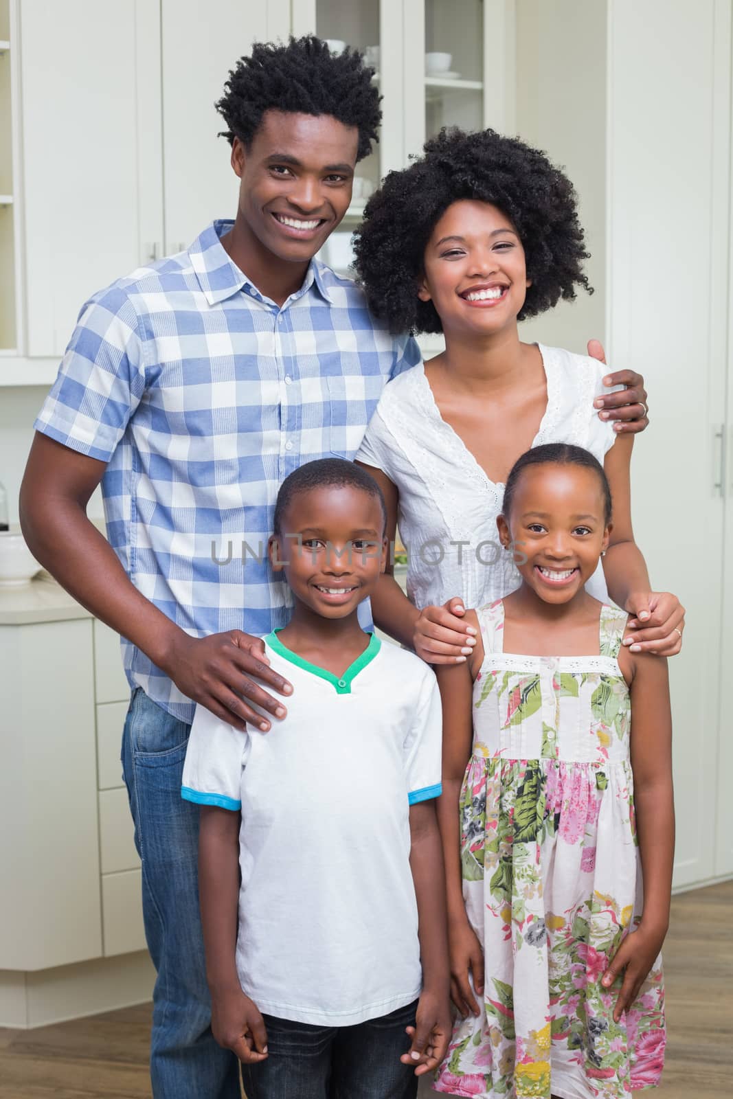 Happy family smiling at camera by Wavebreakmedia