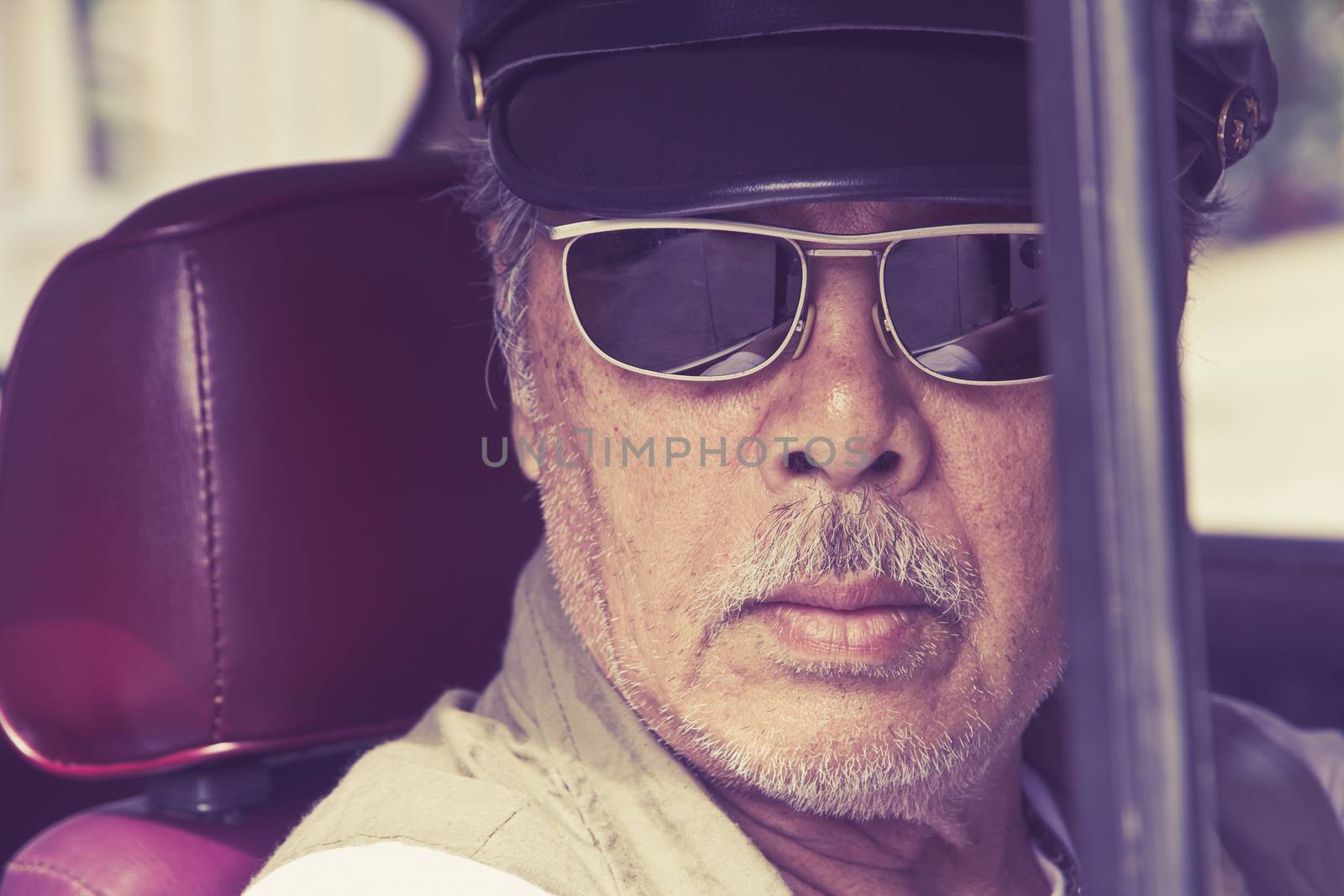 Older man with glasses driving a car by ponsulak